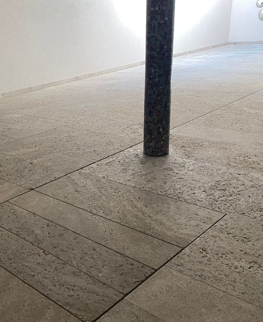 indoor pool with moveable floor in a beige stone